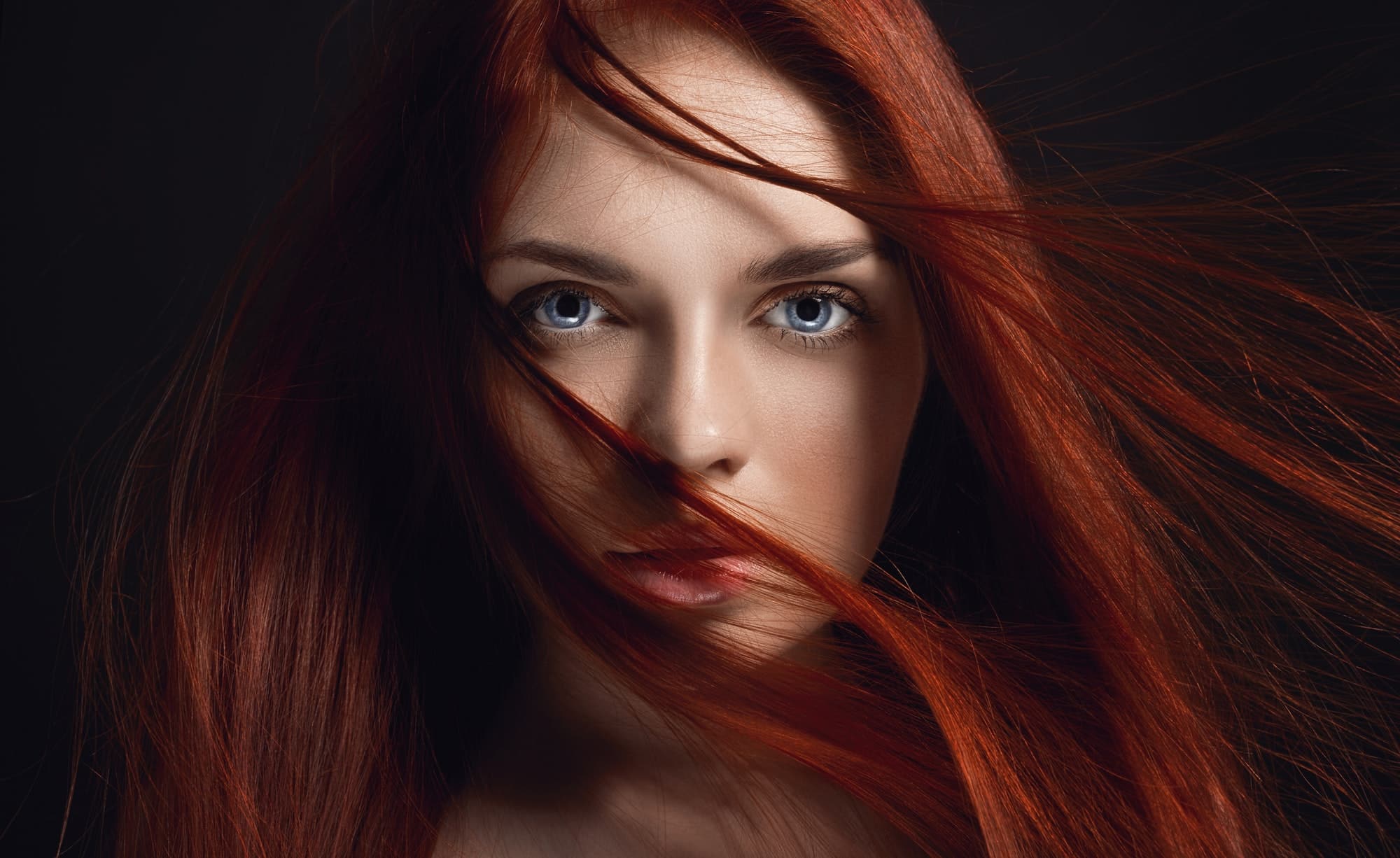Sexy beautiful redhead girl with long hair. Perfect woman portrait on black background. Gorgeous